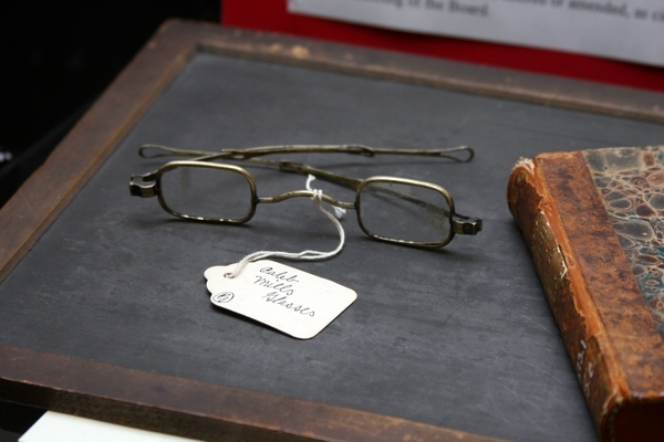 Caleb Mills' glasses, his slate, and his Latin book; on display as part of the Faculty Showcase: Celebrating 175 Years of Excellence