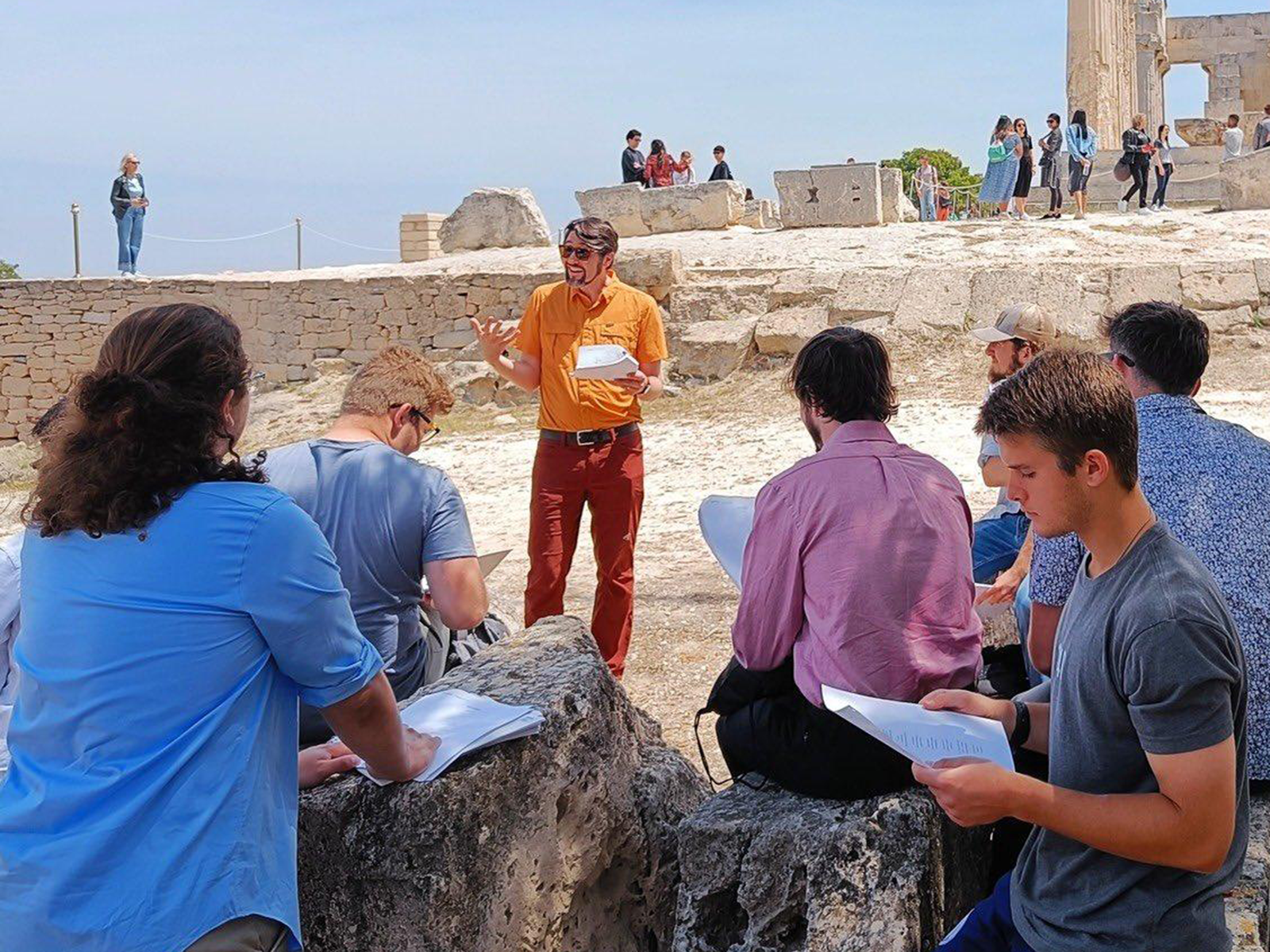 Dr. Mong reads poetry to students at the ruins of Aphaea.