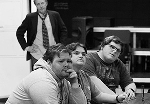 Cast members pictured from left are Josh Campbell ’25 as Juror #10; Jake Weber ’25 as Juror #6, and Alex Schmidt ’27 as Juror #12. At rear is Theater Professor and Juror #3 Michael Abbott ’85.