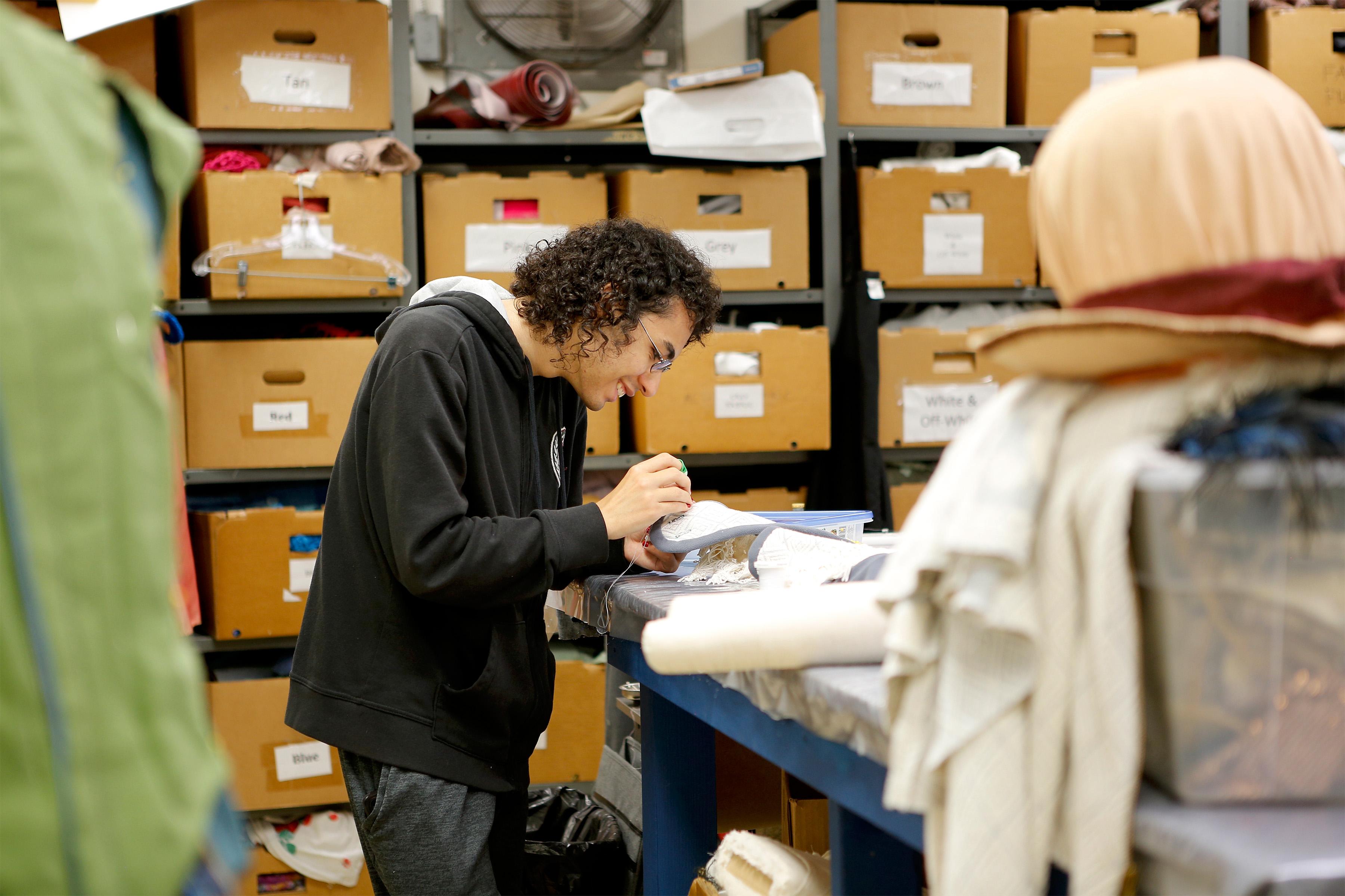 Jacome Huesca working in the Costume Shop on an outfit for "Something Rotten!"