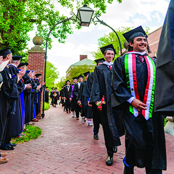 New graduates walk under the Arch