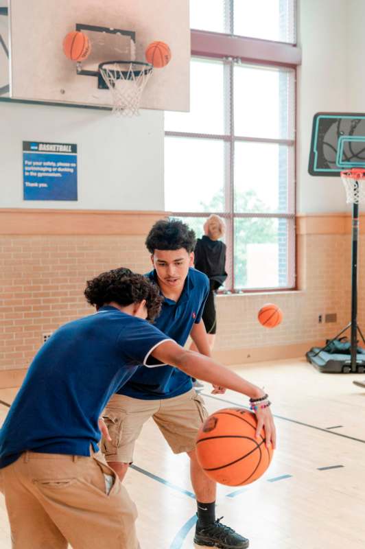 a boy in a blue shirt playing basketball
