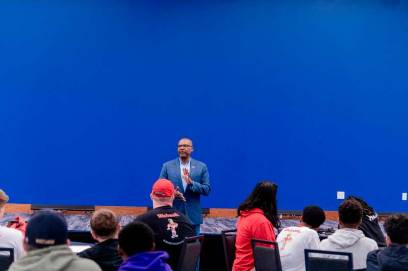 a man standing in front of a large screen