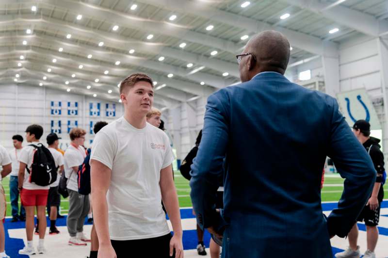 a man talking to a man in a sports hall