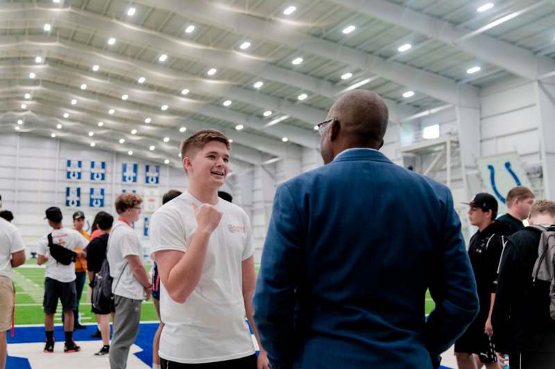 a man talking to a boy in a sports hall