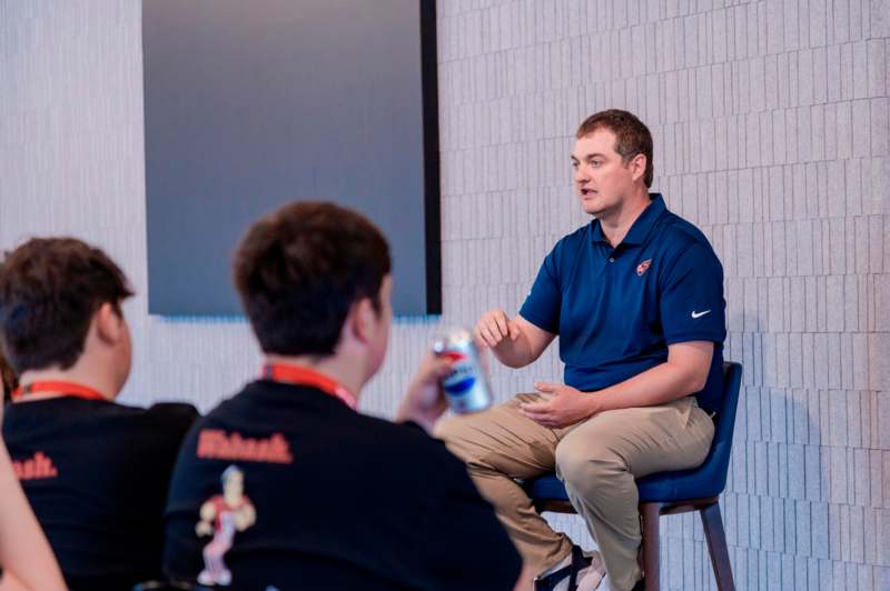 a man sitting in a chair talking to a boy