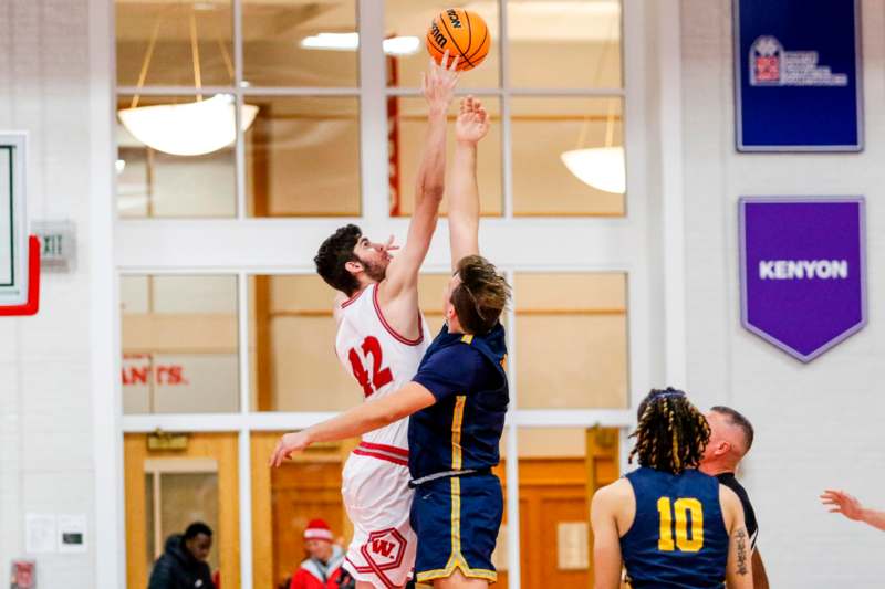 a basketball player reaching for a ball