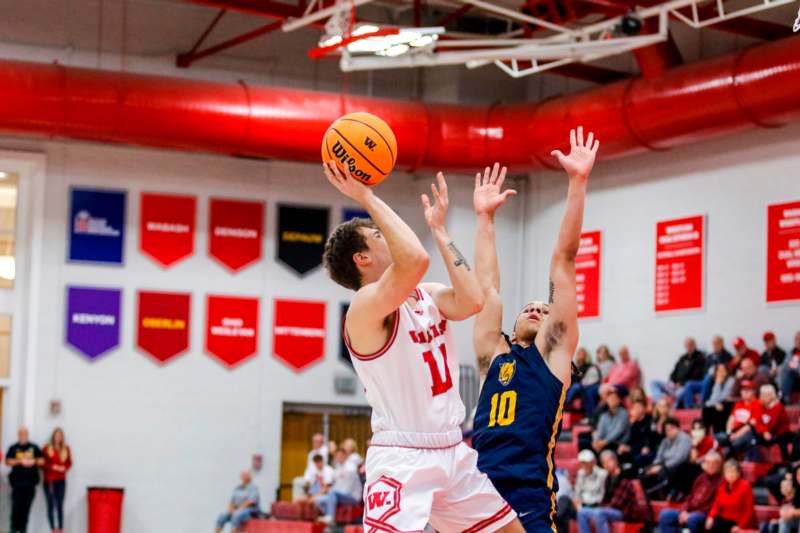 a basketball player in a uniform jumping to shoot a basketball