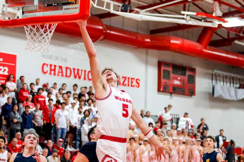 a man in a basketball uniform dunking a basketball hoop