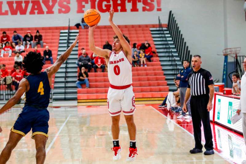 a basketball player in a red uniform with a yellow ball in the air