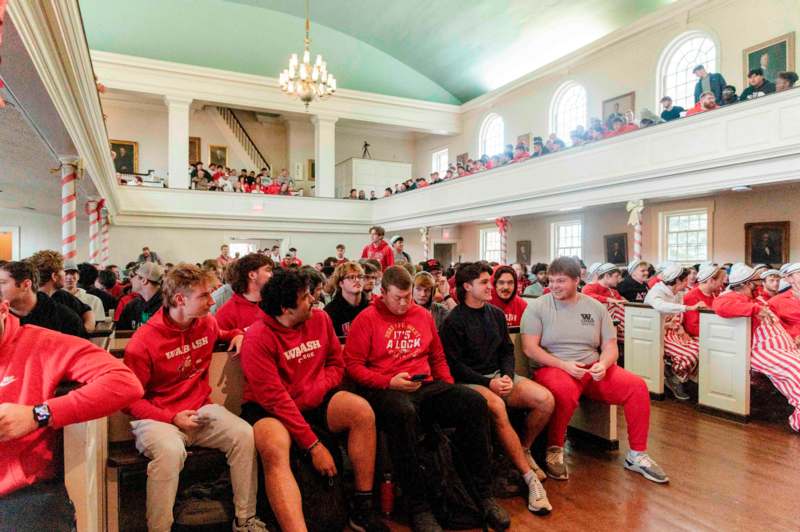 a group of people sitting in a room with a large group of people