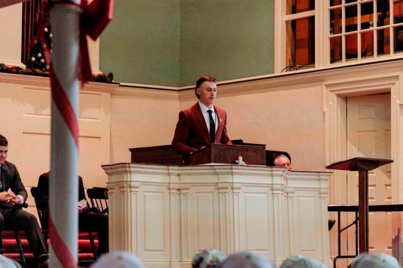 a man in a suit standing at a podium