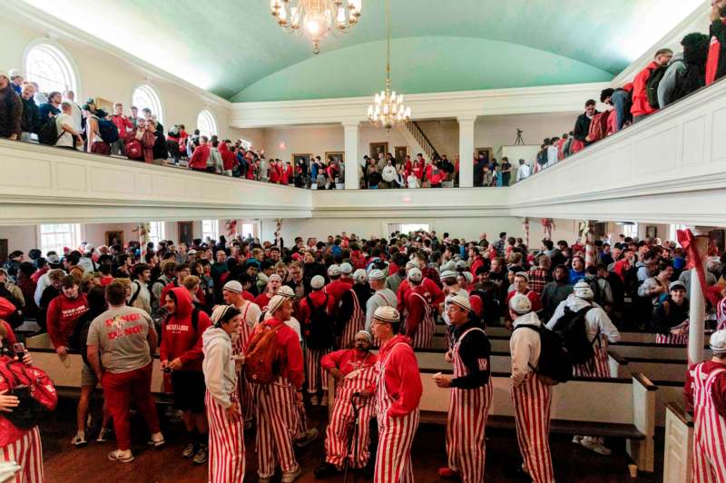 a group of people in striped outfits in a large room