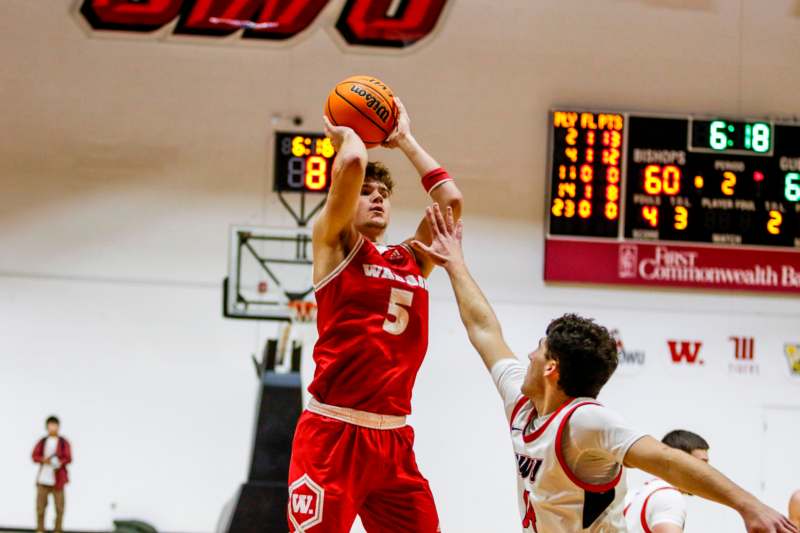 a basketball player in red uniform shooting a basketball