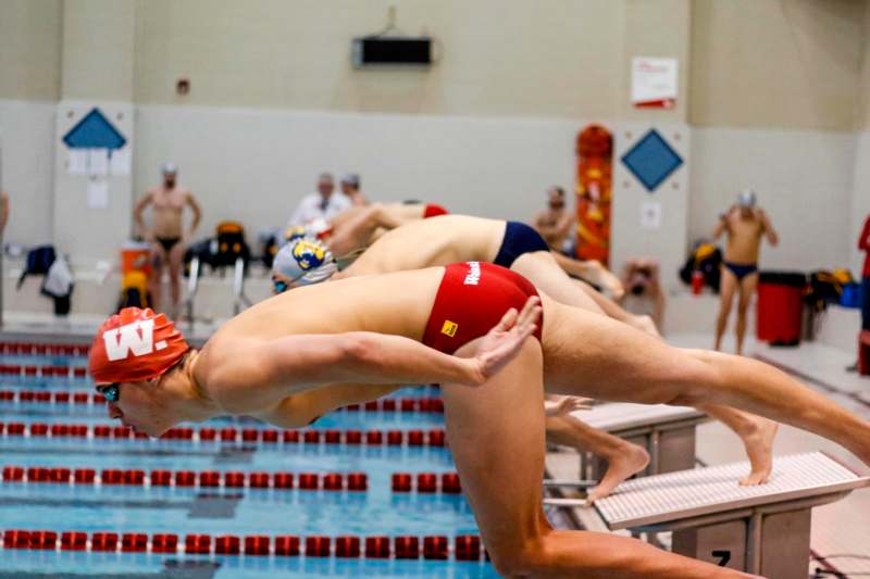 a group of people diving into a pool