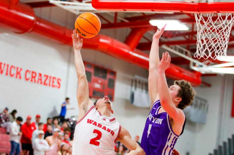 a basketball player reaching for a ball