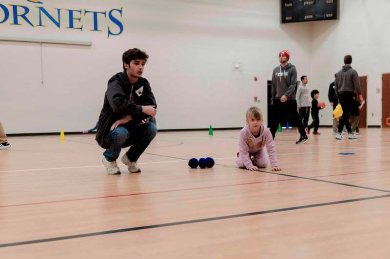 a man kneeling on the floor with a child on the ground