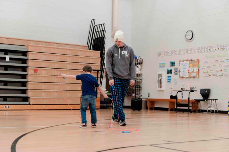 a man and child playing with skipping rope