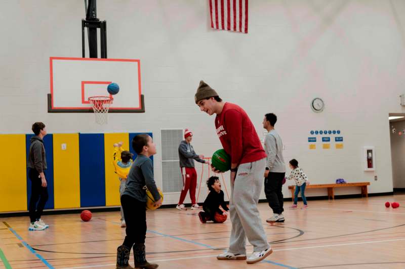 a man holding a ball in a gym