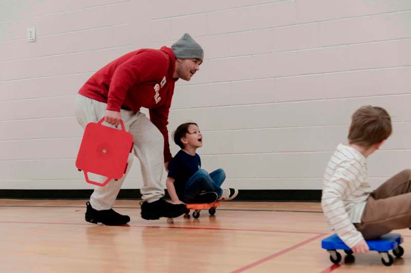 a man pushing a small skateboard with a child on it