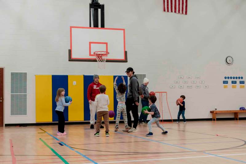 a group of kids playing basketball in a gym