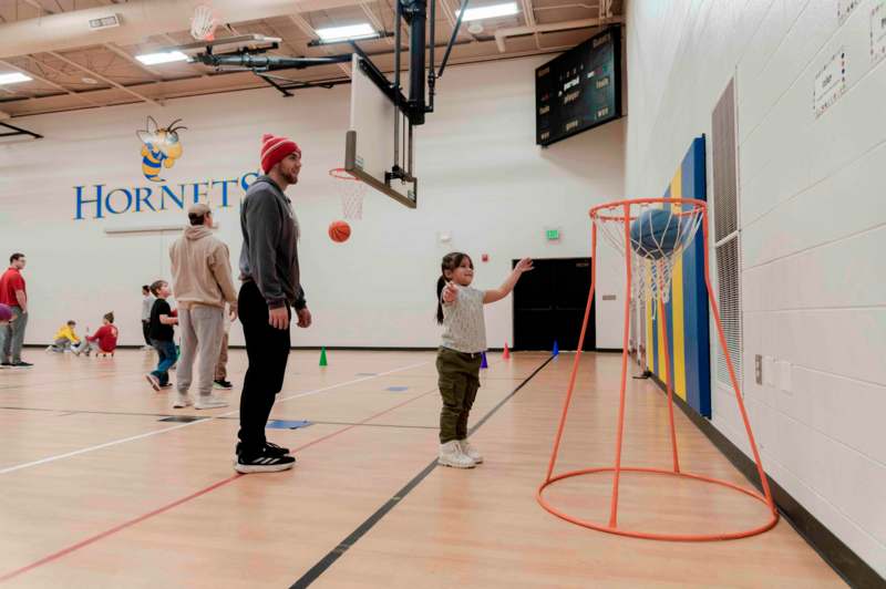 a man and a girl playing basketball