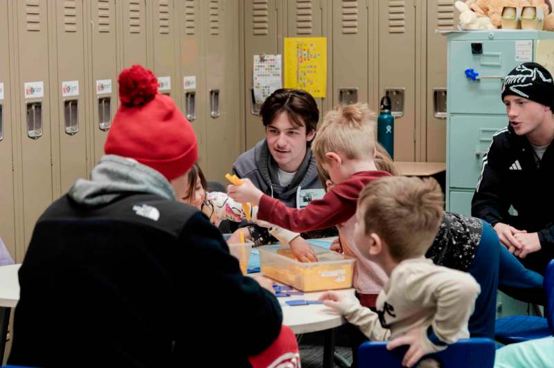 a group of children sitting around a table