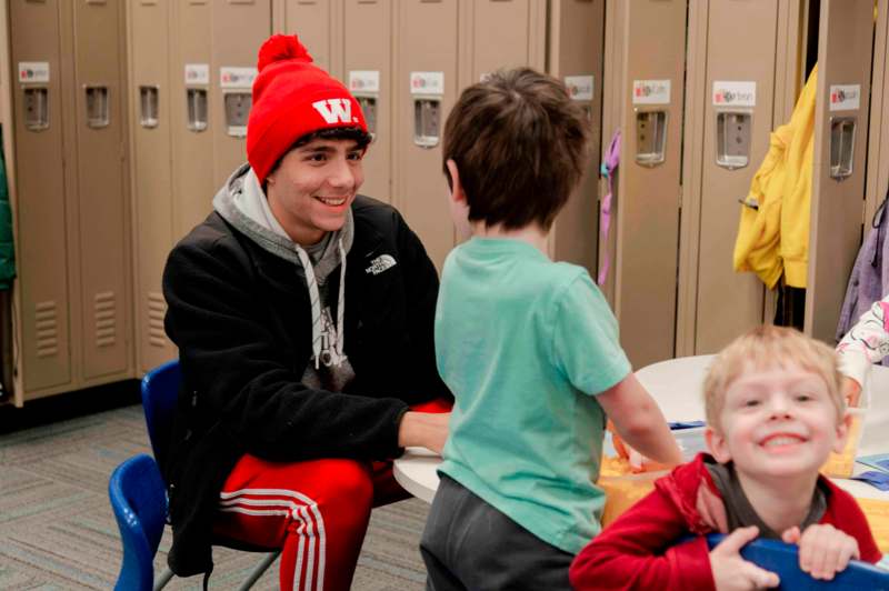 a man sitting at a table with two children