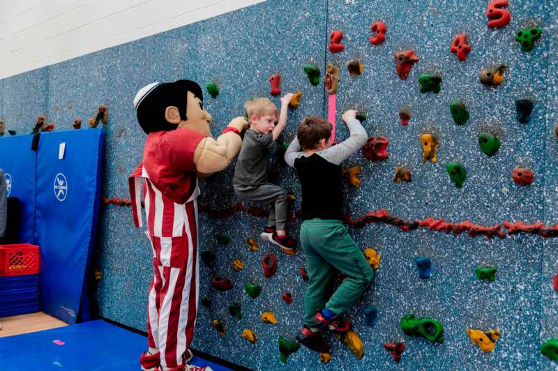 a group of kids climbing a rock wall