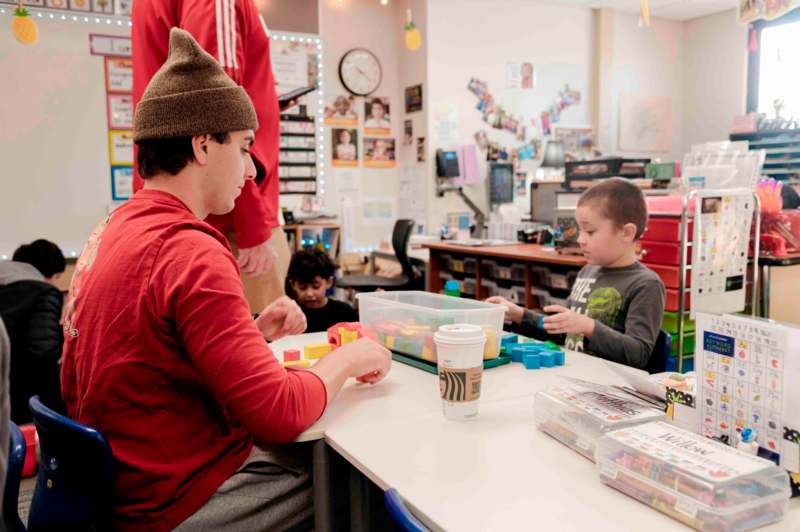 a man and two boys playing with blocks