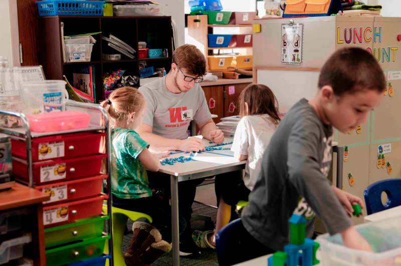 a man and kids sitting at a table