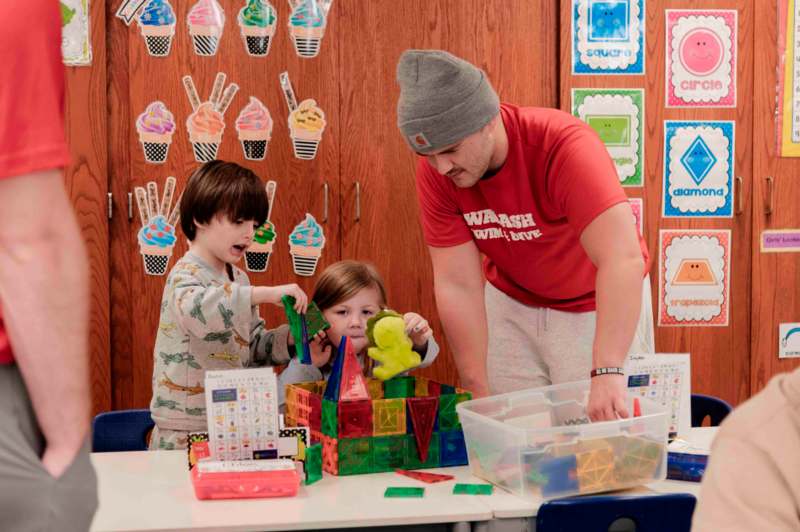 a man and kids playing with blocks