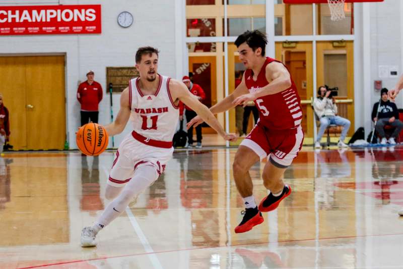 two men playing basketball in a gym