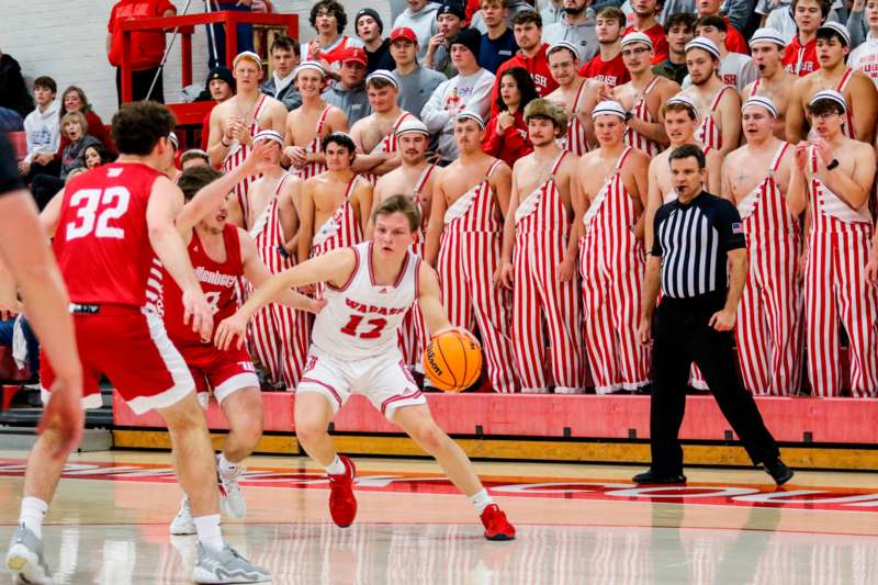 a group of people in red and white striped uniforms playing basketball