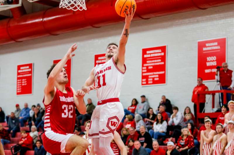 a basketball player in a red uniform jumping to shoot a basketball