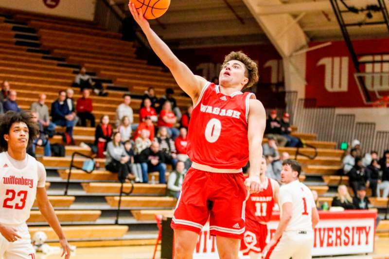 a man in a basketball uniform jumping to shoot a basketball