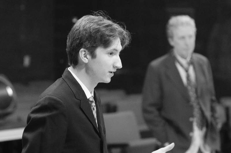 a man in a suit speaking to another man