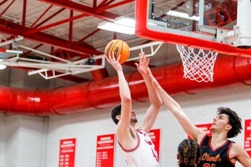 a basketball player reaching for a ball