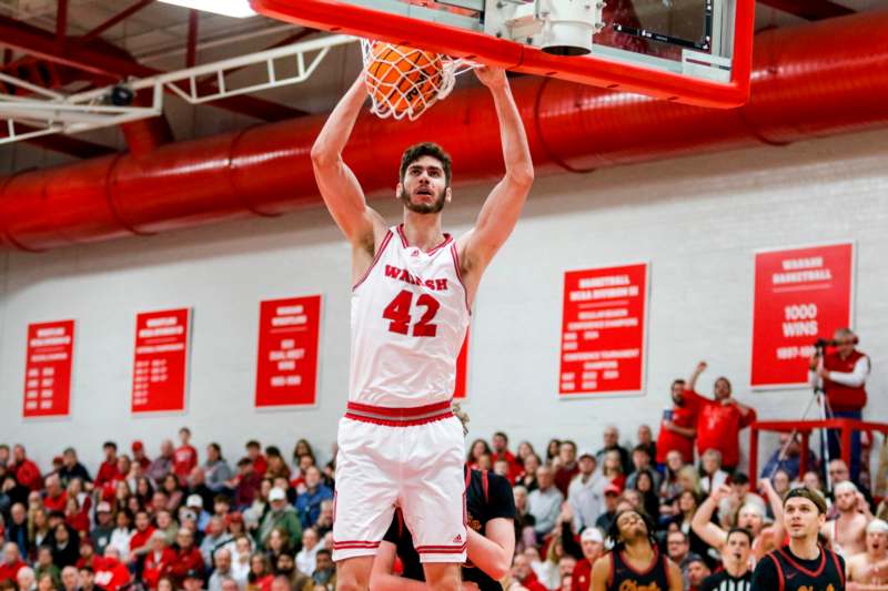 a man in a basketball uniform dunking a basketball hoop