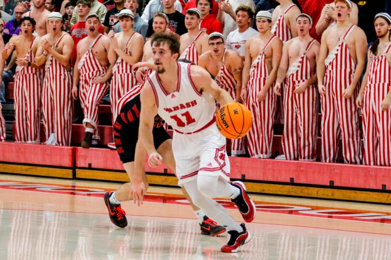 a basketball player running with a ball in front of a crowd