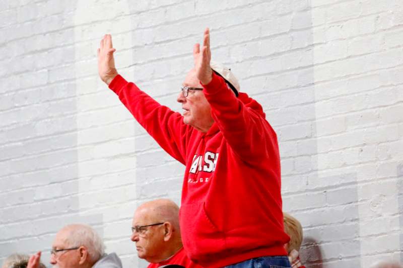 a man in a red sweatshirt raising his hands