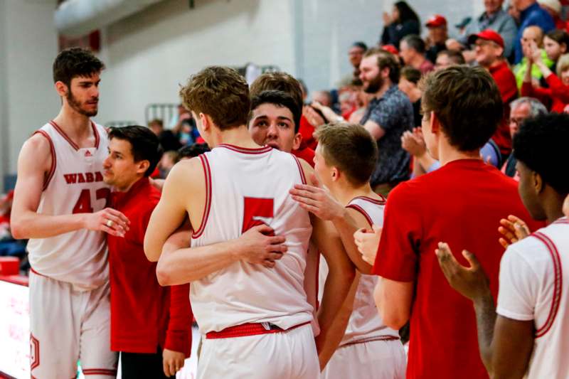 a group of men in sports uniforms hugging each other