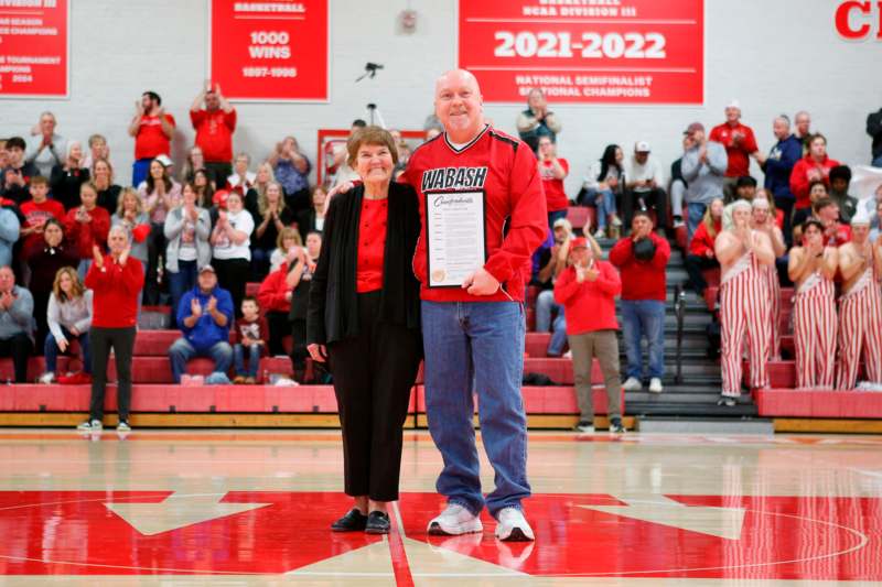 a man and woman standing in a gym with a certificate