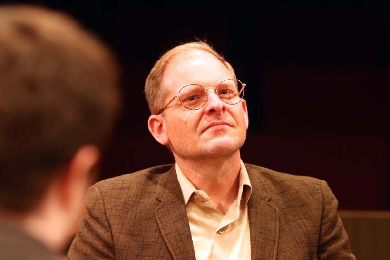 a man in a brown suit and glasses