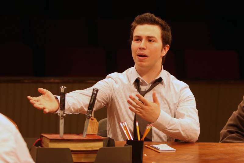 a man sitting at a table with a knife and a book