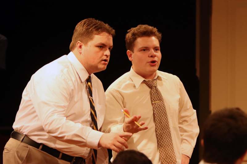 two men in ties standing on a stage