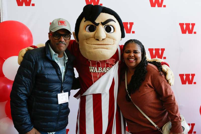 a man and woman posing with a mascot