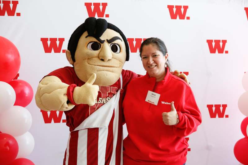 a woman posing with a mascot