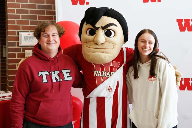 a man and woman posing with a mascot