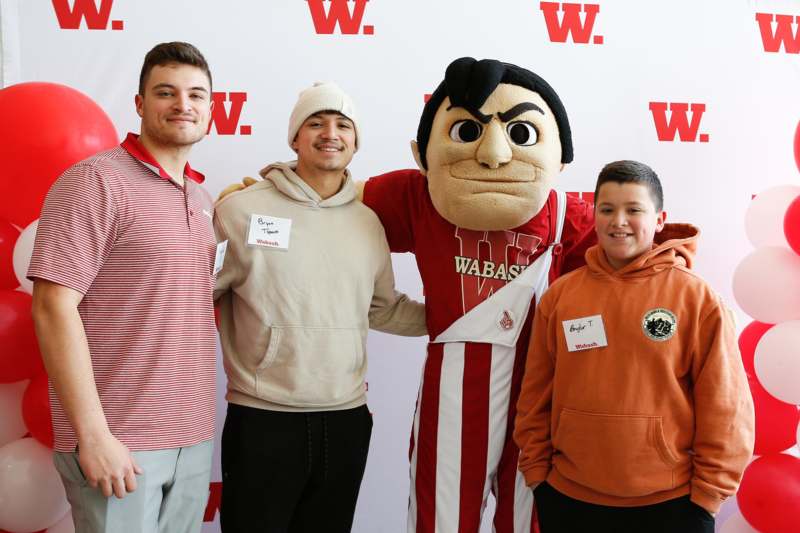 a group of men posing with a mascot